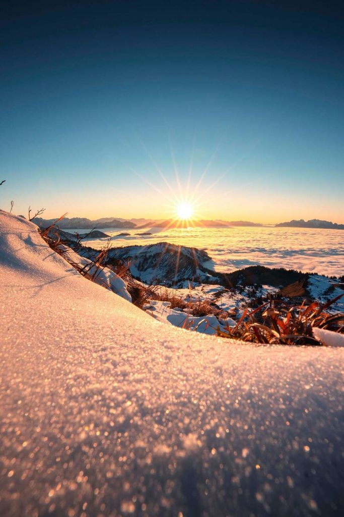 Sonnenschein über verschneiter Alpenflanke