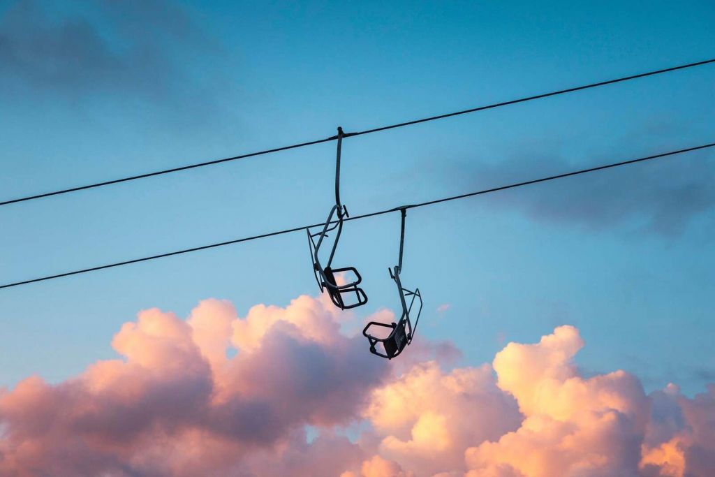 Sessellift über rosa Abendwolken
