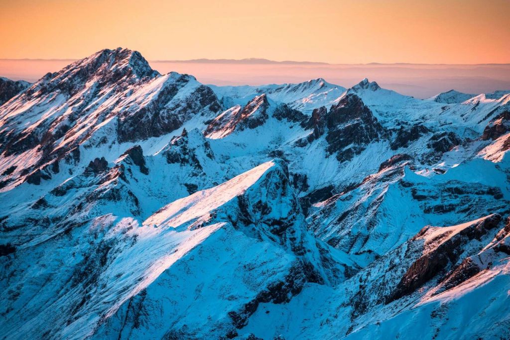 Sonnenaufgang über verschneitem Bergmassiv