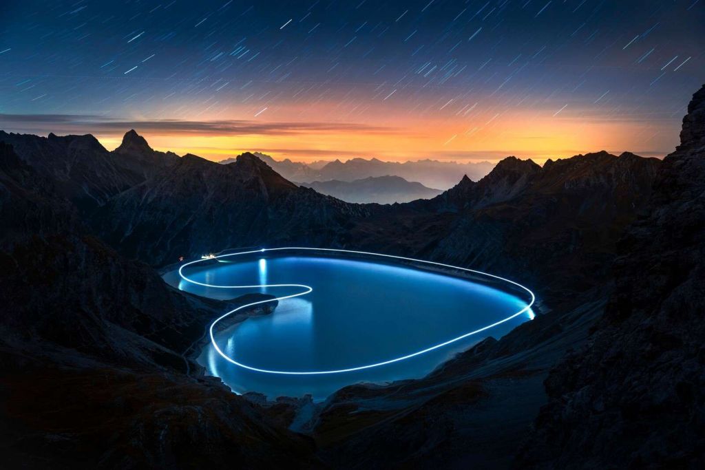 Lichtpfad um Bergsee bei Nacht