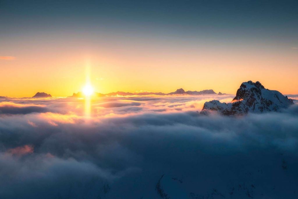 Sonnenaufgang über Wolkenmeer und Berggipfeln