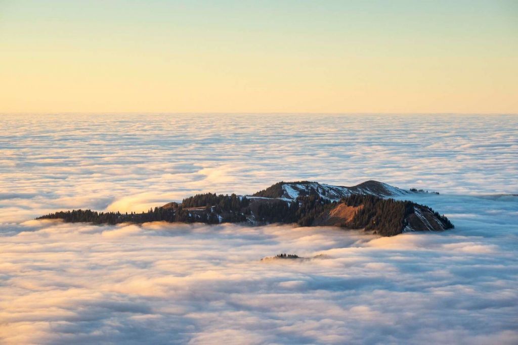 Bergkamm treibend in Wolkenmeer.