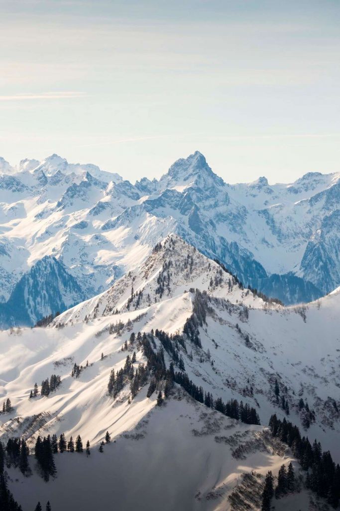 Winterlandschaft mit Alpengipfeln im Sonnenlicht.