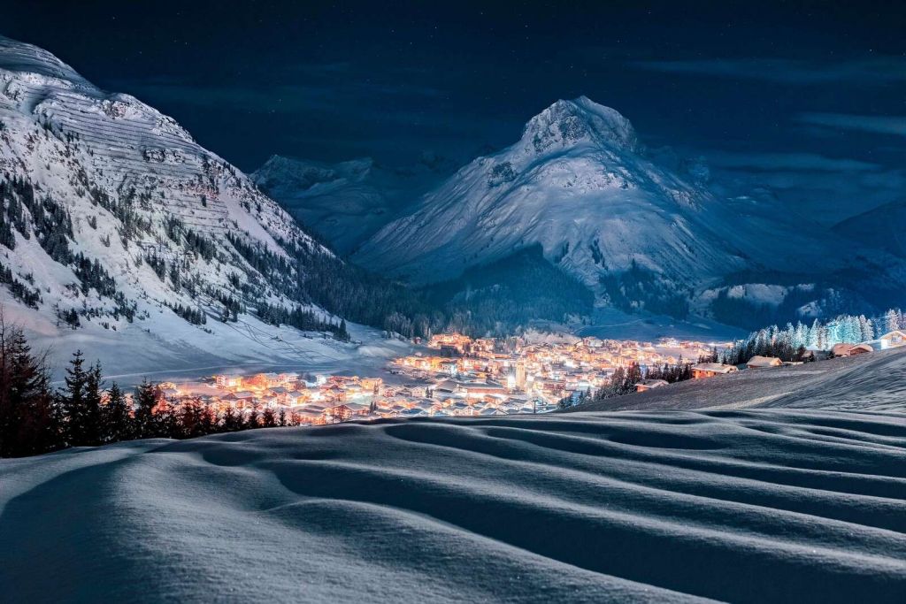 Winterdorf im Mondlicht im Alpental.