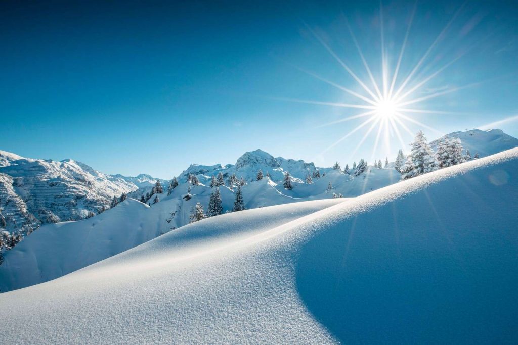 Sonnenschein über glitzernden Schneehügeln