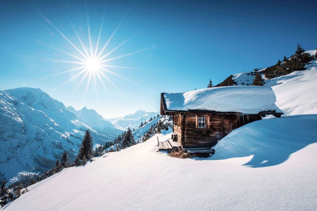 Winter Sonne über Holzhütte in den Bergen.