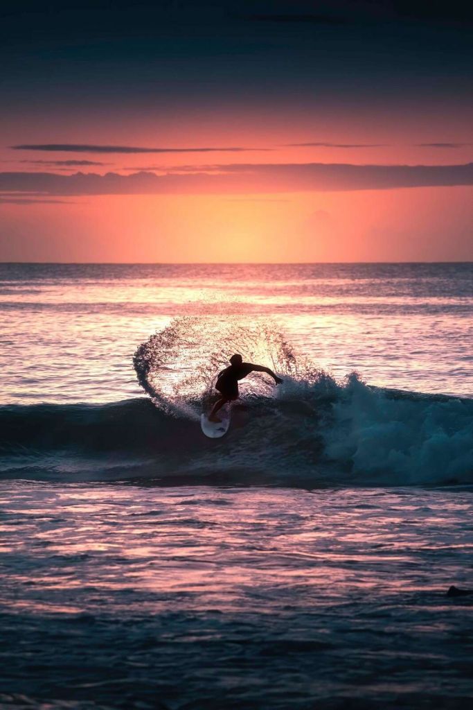 Surfer im rosa Abendlicht.