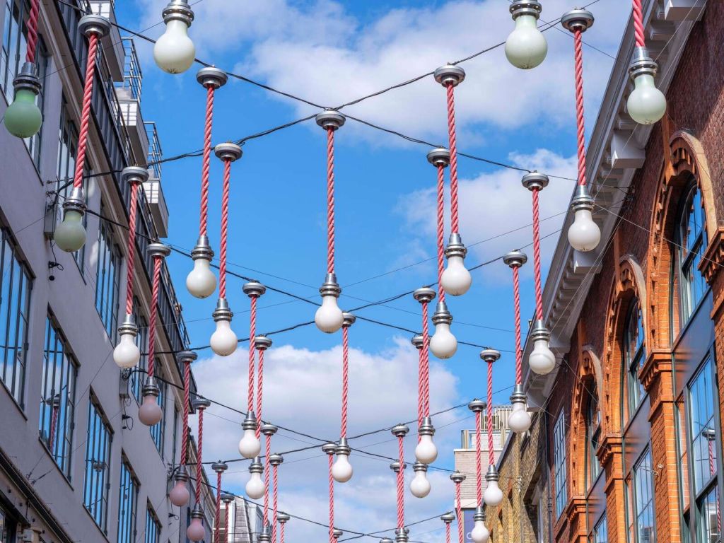 Glühbirnen hängen über den Gebäuden für Weihnachtsdekorationen, London.