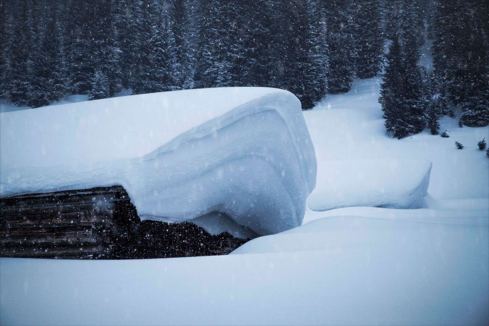 Beschneite Alpenhütte im Wintersturm