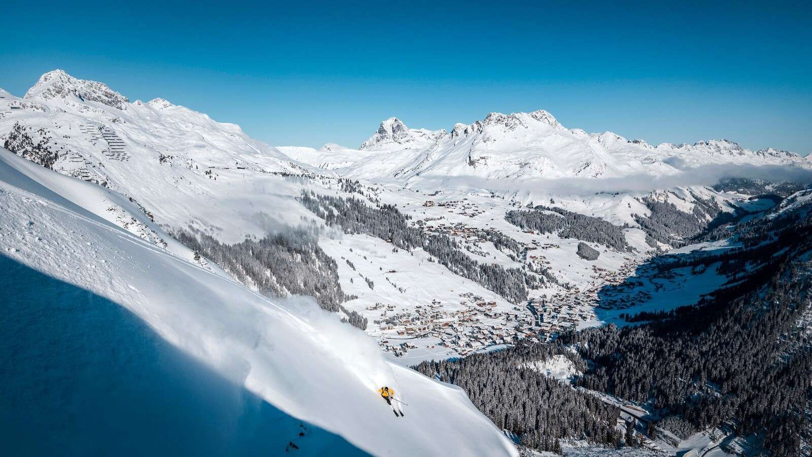 Abfahrt über einem Alpendorf im Schnee