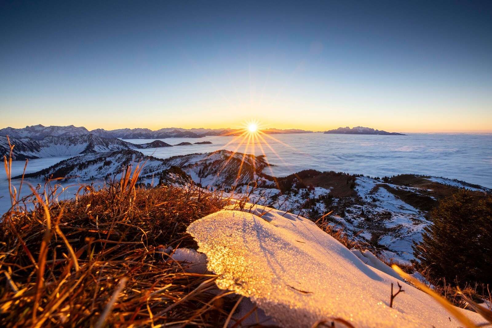 Sonnenaufgang über winterlicher Bergwiese
