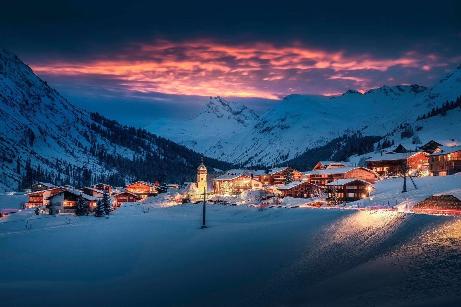 Abendlicht über Bergdorf im Schnee