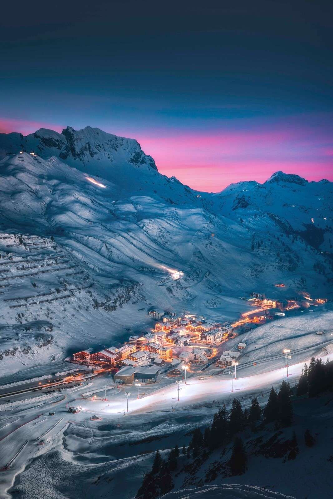 Schneedorf unter violettem Abendhimmel.