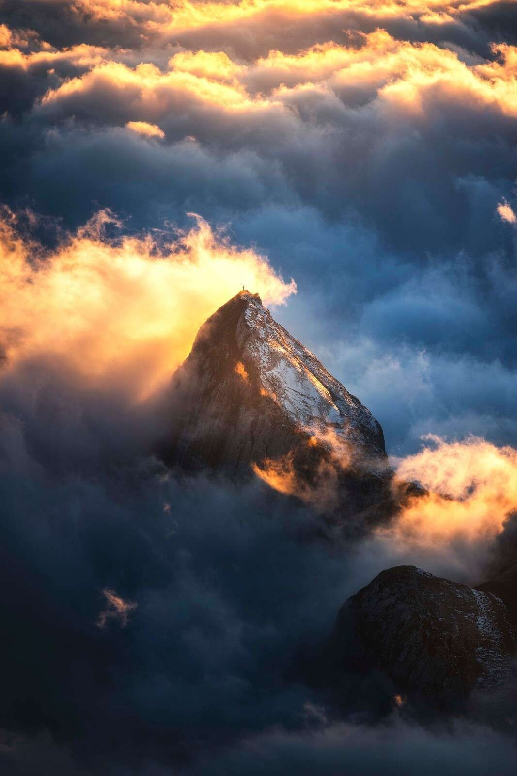 Bergkreuz in feurigem Nebel