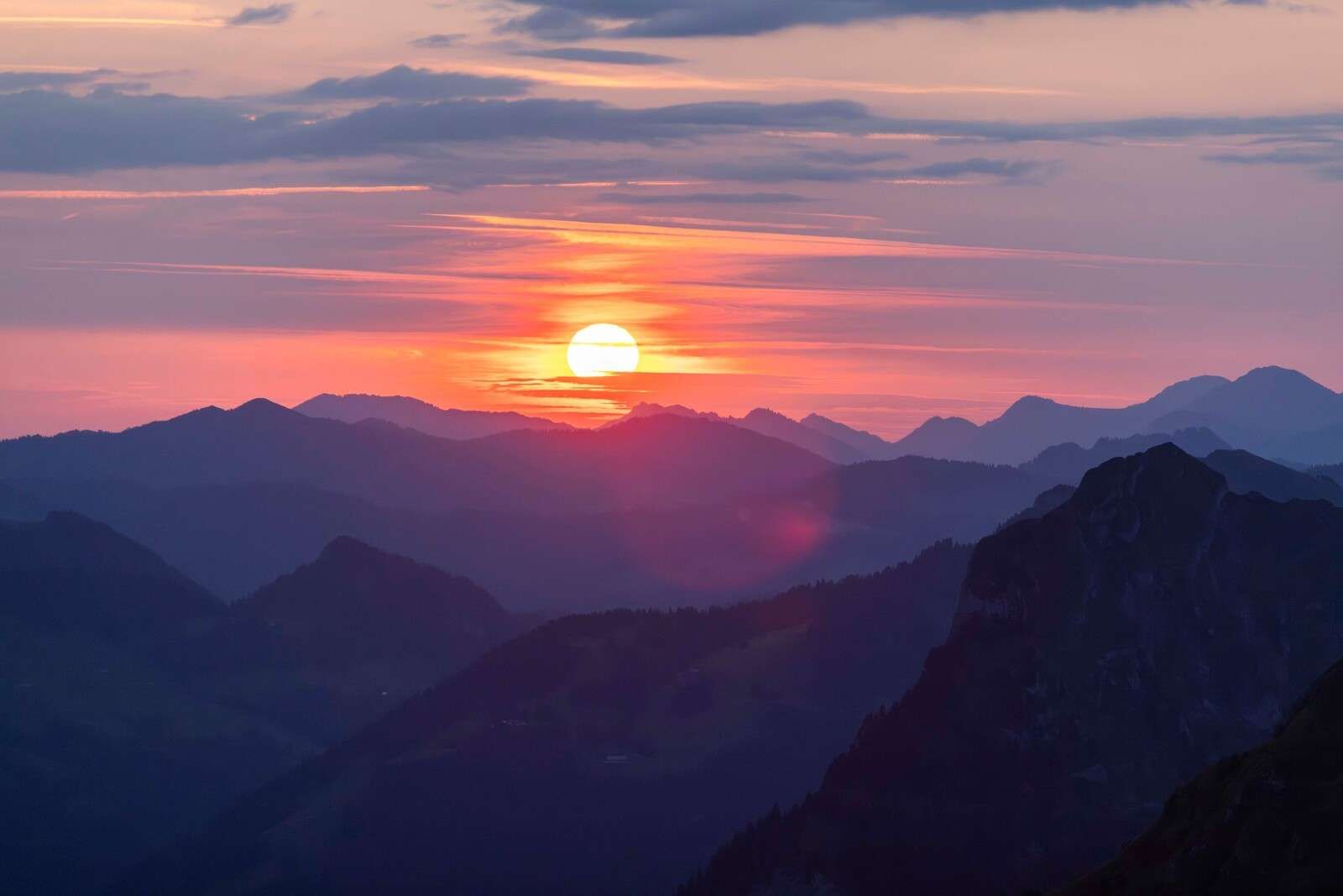 Sonnenuntergang über violetten Bergschichten