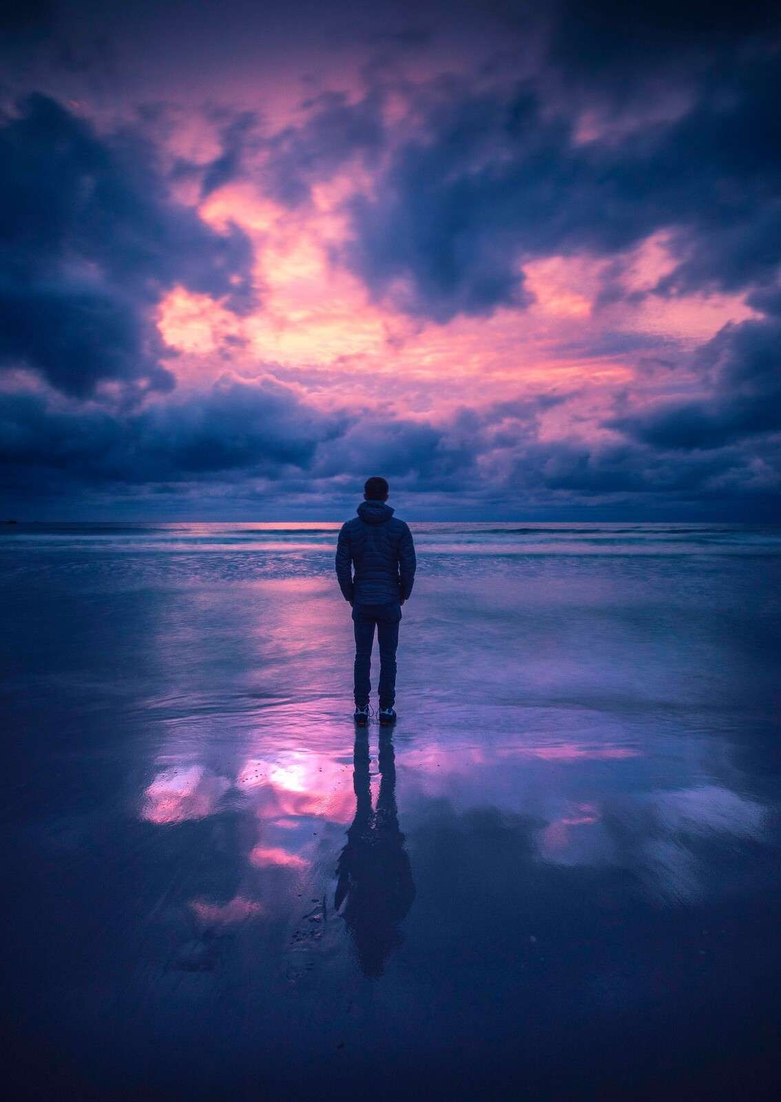 Lila Dämmerung an ruhiger Küste.