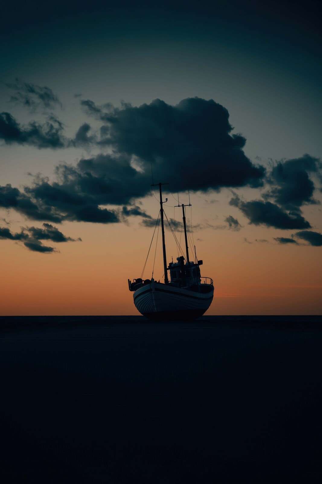 Gestrandetes Fischerboot bei Sonnenuntergang
