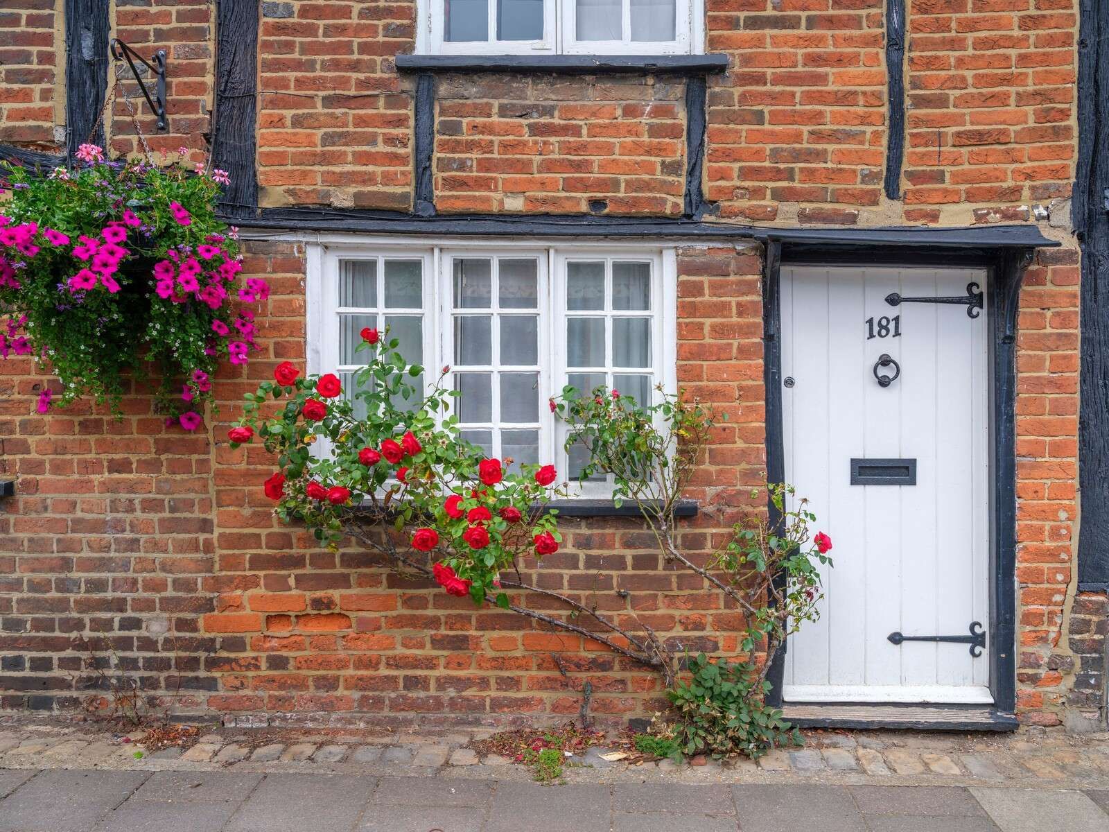 Backsteincottage mit roten Rosen